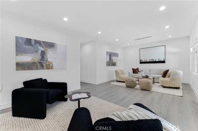living area featuring recessed lighting, baseboards, and wood finished floors