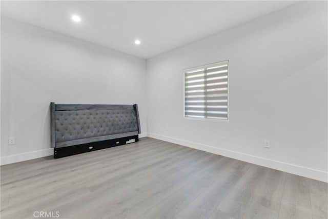 bedroom with wood finished floors, baseboards, and recessed lighting