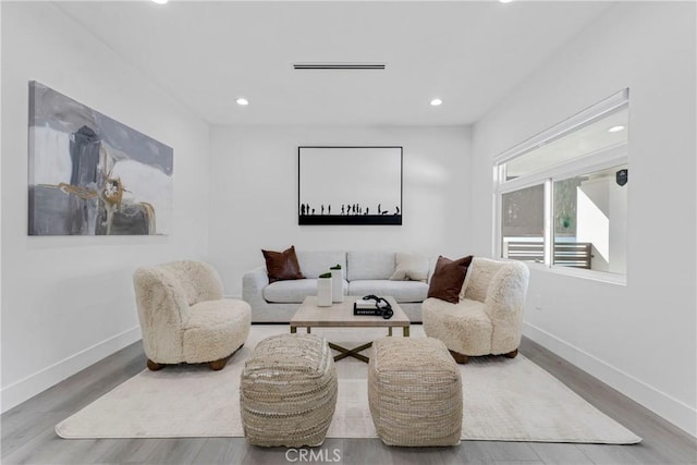 living area with baseboards, recessed lighting, and wood finished floors