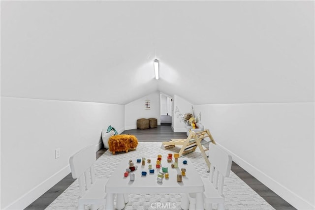 recreation room with wood finished floors, baseboards, and lofted ceiling