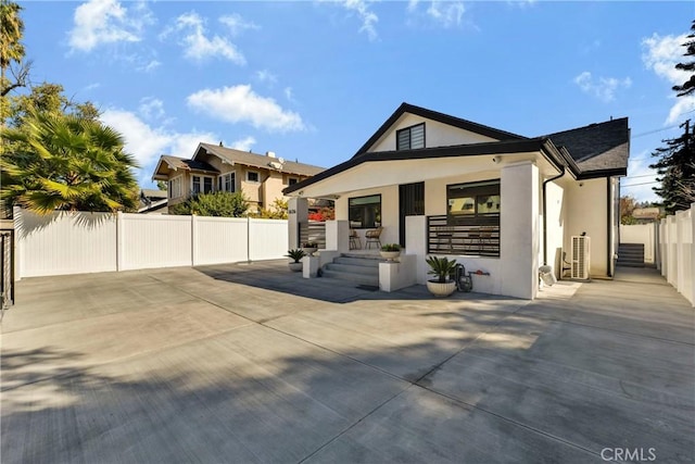 exterior space featuring stucco siding, covered porch, and fence