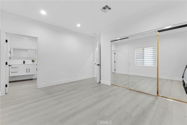 unfurnished bedroom with visible vents, light wood-style flooring, baseboards, and recessed lighting
