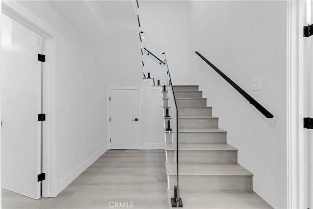 stairs with wood finished floors and baseboards
