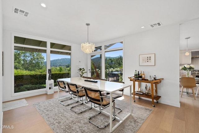 dining space with recessed lighting, light wood-style floors, an inviting chandelier, and visible vents