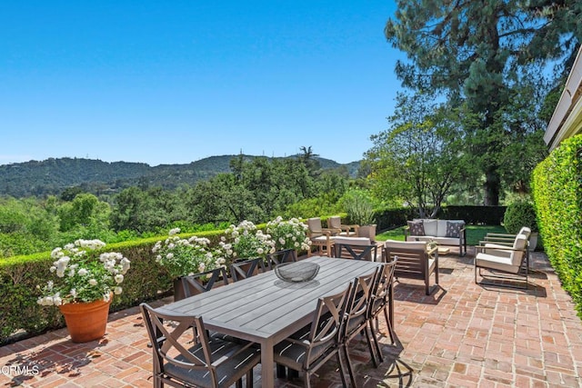 view of patio with an outdoor living space, outdoor dining area, and a mountain view