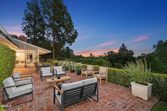 patio terrace at dusk featuring an outdoor hangout area