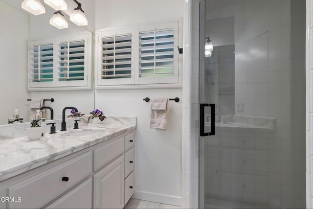full bathroom with a stall shower, vanity, and baseboards