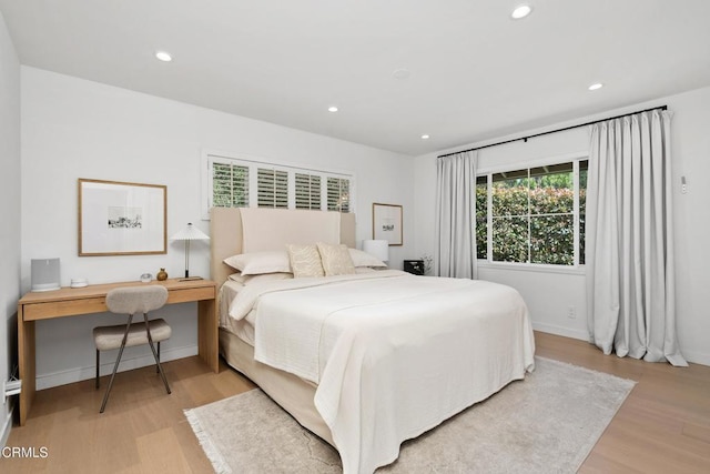 bedroom with light wood-style flooring, baseboards, and recessed lighting