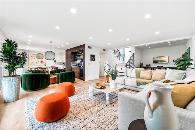 living area featuring stairway, recessed lighting, visible vents, and light wood-style floors