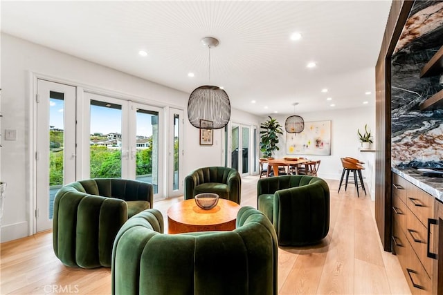 living room with light wood-style floors, french doors, and recessed lighting
