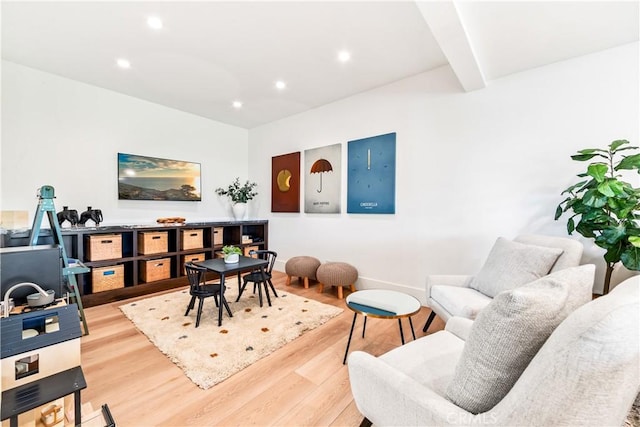 living room featuring light wood finished floors, baseboards, beamed ceiling, and recessed lighting