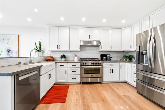 9 Jasmine Creek Dr, Corona Del Mar, CA 92625 - kitchen featuring appliances with stainless steel finishes, under cabinet range hood, a peninsula, a sink, and tasteful backsplash