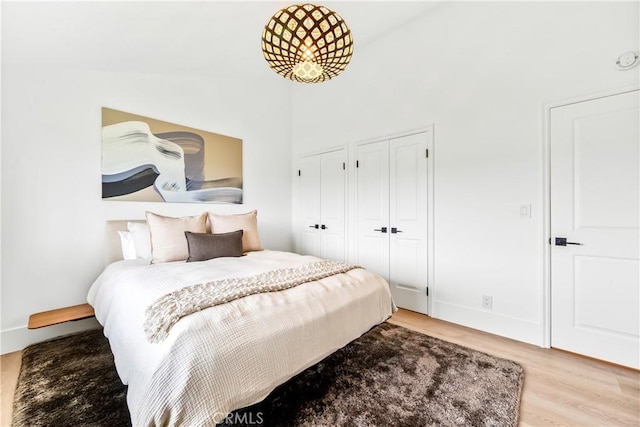 9 Jasmine Creek Dr, Corona Del Mar, CA 92625 - bedroom with wood finished floors, multiple closets, a towering ceiling, and baseboards