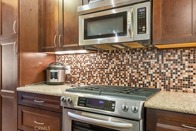 23697 Bowl Rd, Crestline, CA 92325 - kitchen featuring light stone counters, stainless steel appliances, tasteful backsplash, and dark brown cabinets