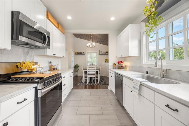 521 N Vine St, Anaheim, CA 92805 - kitchen with stainless steel appliances, a sink, healthy amount of natural light, a chandelier, and lofted ceiling