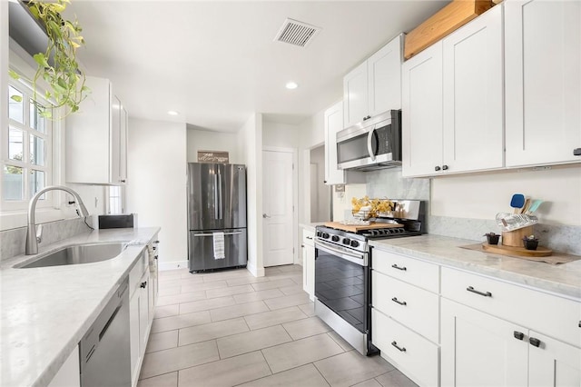 521 N Vine St, Anaheim, CA 92805 - kitchen featuring stainless steel appliances, a sink, white cabinets, recessed lighting, and light stone counters