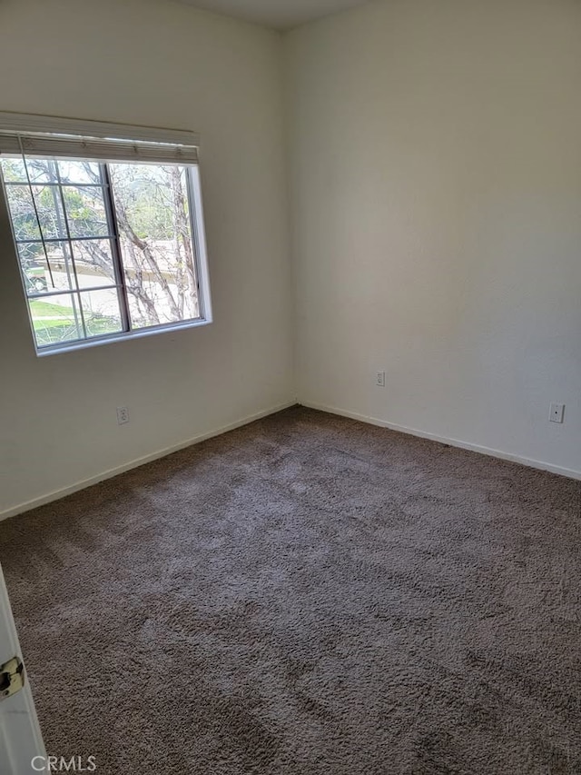 carpeted spare room with baseboards