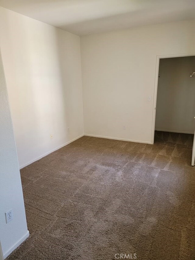 carpeted empty room with baseboards