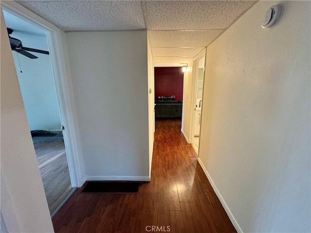 corridor with baseboards and dark wood finished floors