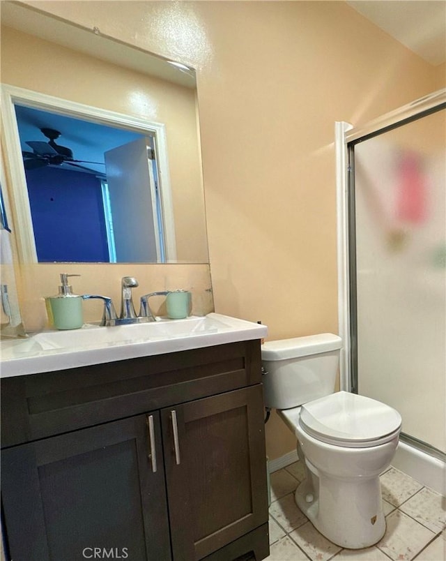 full bathroom featuring toilet, a stall shower, baseboards, tile patterned flooring, and vanity