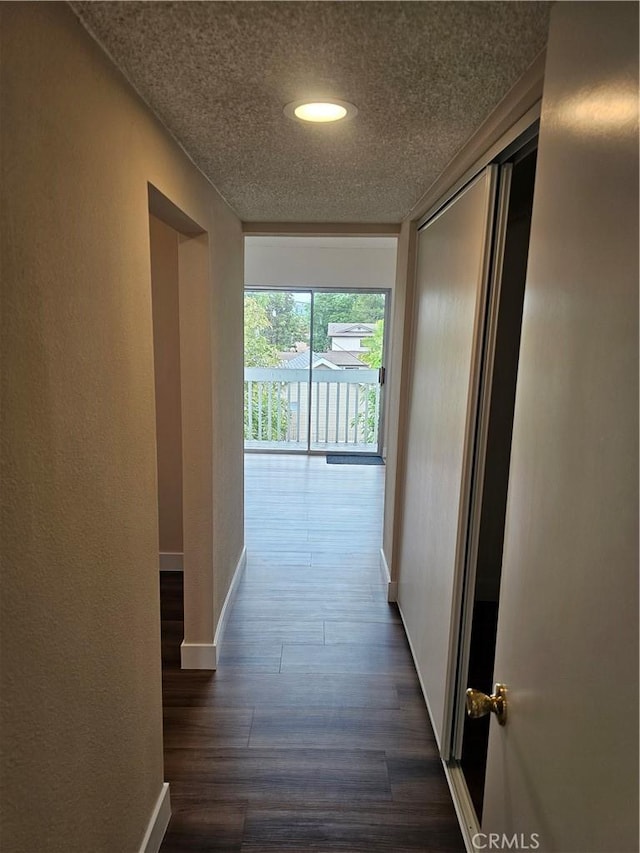 hallway featuring baseboards, dark wood-style floors, recessed lighting, and a textured ceiling