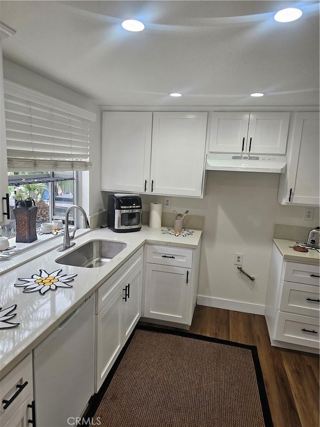 kitchen featuring under cabinet range hood, light countertops, dark wood-style floors, and a sink