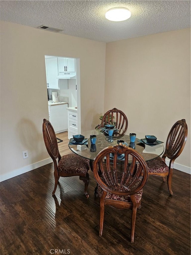 dining space featuring washer / clothes dryer, a textured ceiling, visible vents, light wood-style flooring, and baseboards