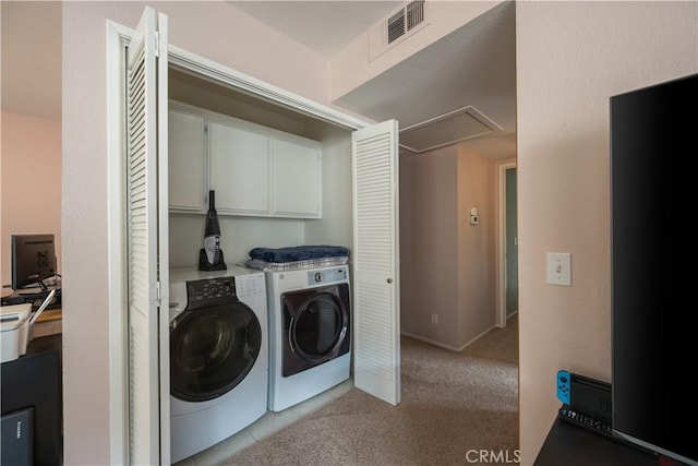 laundry area with washing machine and dryer, attic access, visible vents, cabinet space, and light colored carpet