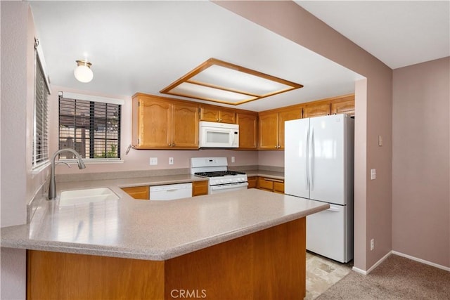 kitchen featuring a sink, a peninsula, white appliances, and light countertops