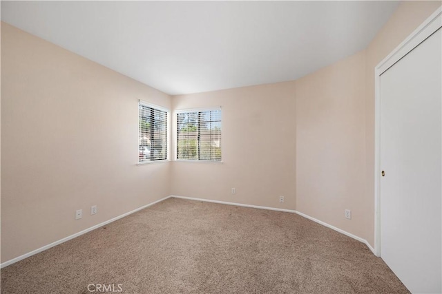carpeted spare room with baseboards