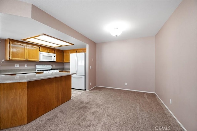 kitchen with a peninsula, brown cabinetry, white appliances, light carpet, and baseboards