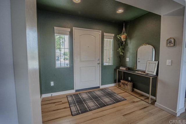 entryway with wood finished floors, baseboards, and recessed lighting