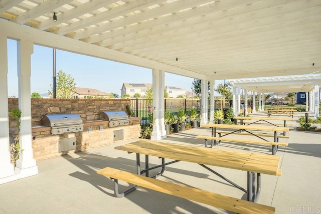 view of patio with grilling area, an outdoor kitchen, and fence