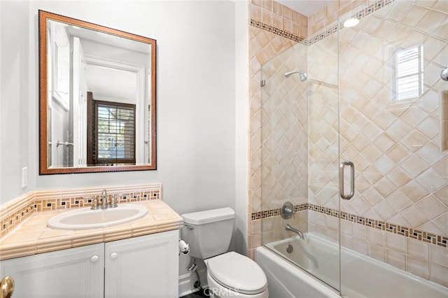full bath featuring enclosed tub / shower combo, vanity, and toilet