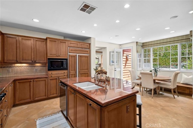 kitchen with a sink, built in appliances, visible vents, and brown cabinets