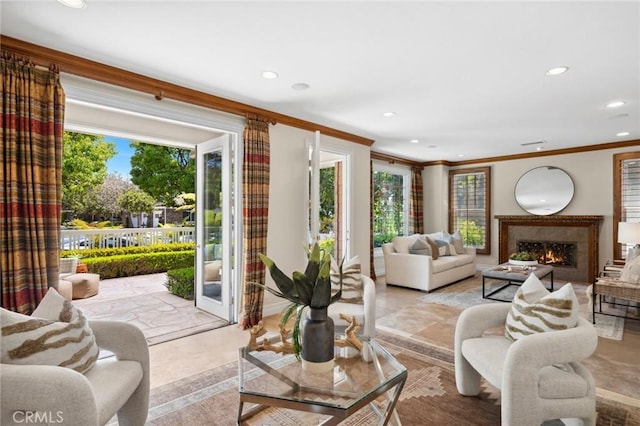 living area featuring a warm lit fireplace, ornamental molding, and recessed lighting