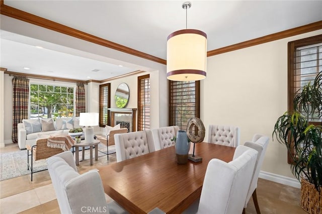dining area featuring crown molding, baseboards, and light tile patterned flooring