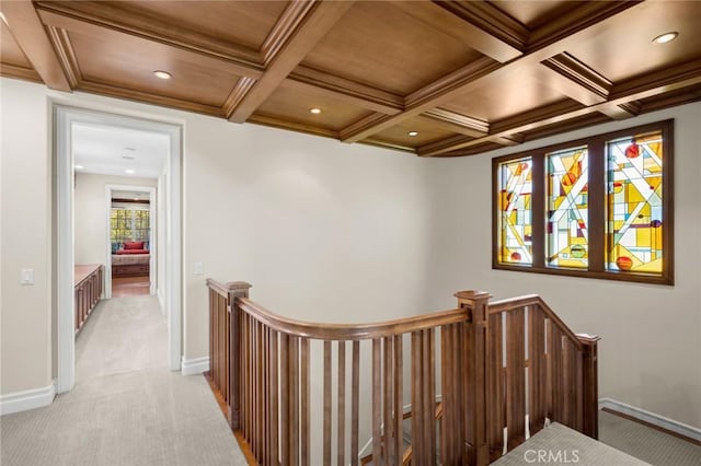 hall with baseboards, light colored carpet, an upstairs landing, and coffered ceiling