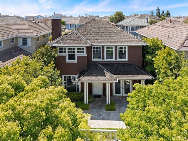 exterior space featuring a chimney, a residential view, and french doors