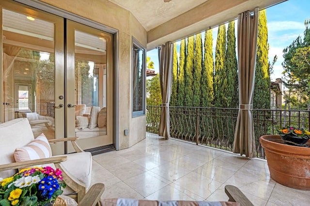 sunroom / solarium with tile patterned flooring and french doors