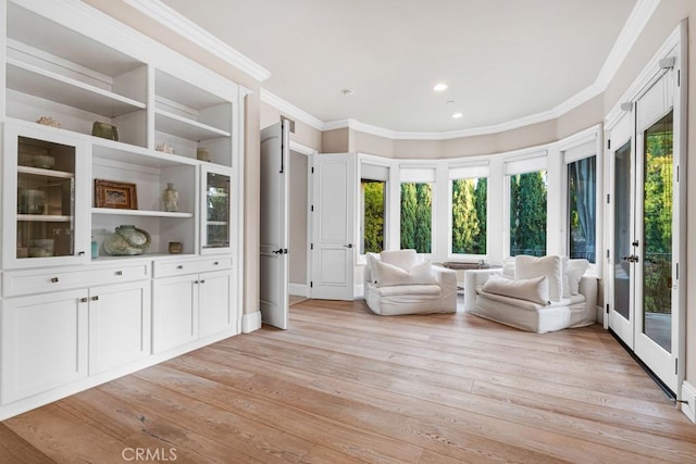 living area with recessed lighting, light wood-style floors, french doors, and crown molding