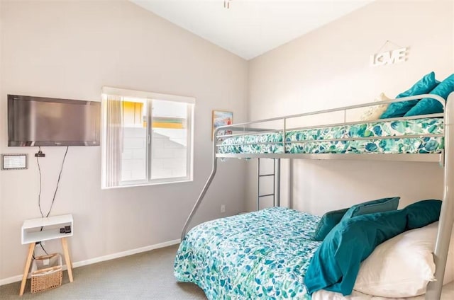 bedroom featuring baseboards, carpet flooring, and vaulted ceiling