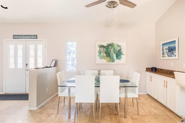 dining space featuring baseboards, light tile patterned floors, and ceiling fan