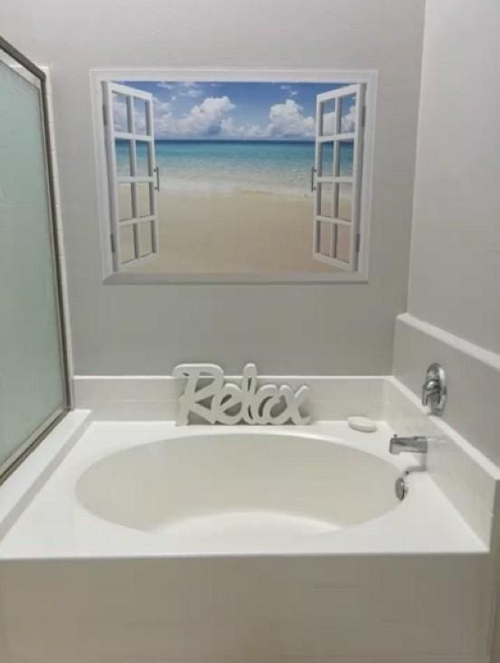 bathroom with a water view and a garden tub