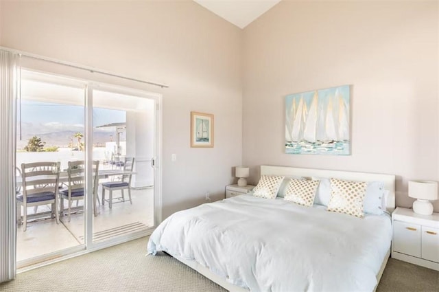carpeted bedroom featuring access to exterior and high vaulted ceiling