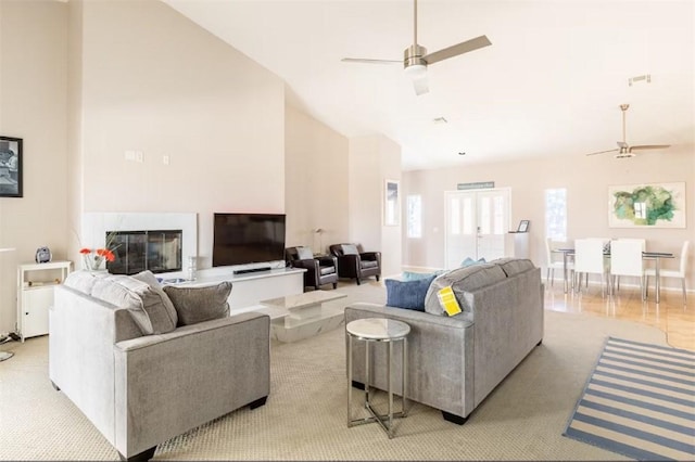 living area featuring a fireplace, ceiling fan, vaulted ceiling, and visible vents