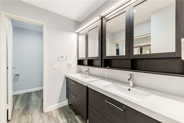 bathroom with baseboards, vanity, and wood finished floors