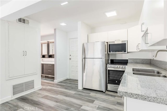kitchen featuring a sink, light wood-style flooring, visible vents, and appliances with stainless steel finishes