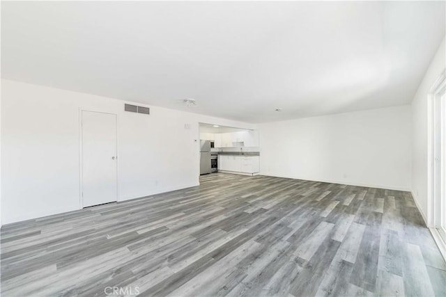 unfurnished living room featuring light wood-type flooring and visible vents