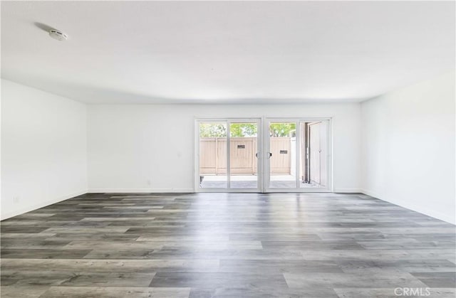 spare room featuring baseboards, french doors, and wood finished floors